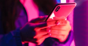Woman Posing over Neon Lights Using Mobile Phone